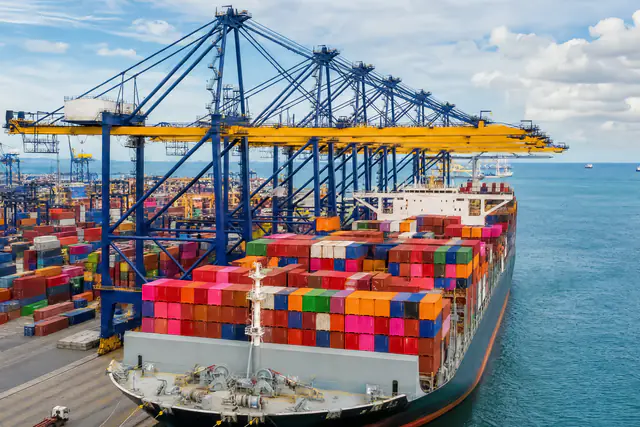 Buque atracado junto a grúas pórtico en una terminal de contenedores