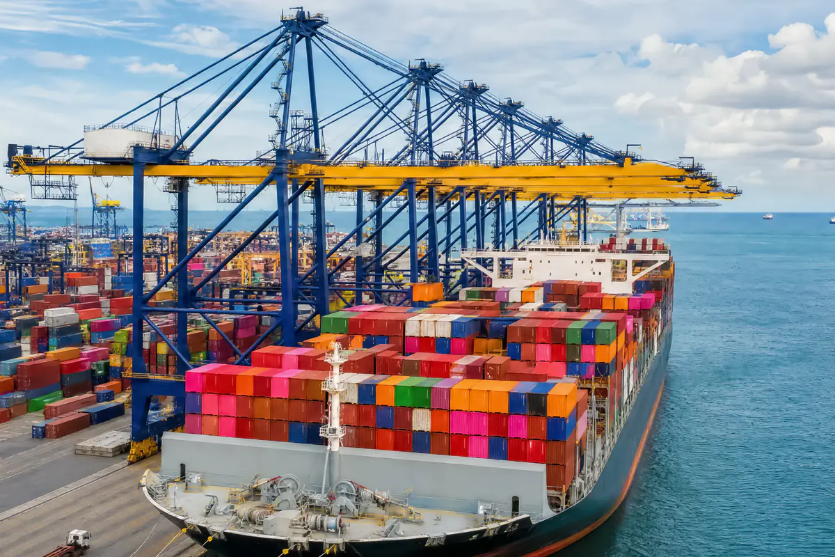 Buque atracado junto a grúas pórtico en una terminal de contenedores